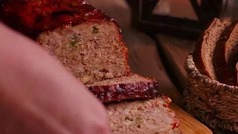 Close up placing board of meatloaf slices on rustic wooden table Stock Footage 326321121