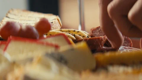 Close up placing salami onto brie bread and dip. Stock Footage 89993989