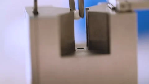 Close Up of Placing Tiny Ball into a Hole with Tweezers Stock Footage 145056035