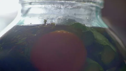 Close-Up Plan of Air Bubbles Rise to Surface in Glass Bank with Cucumbers Filled Stock Footage 94236047