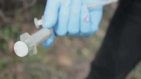 Close plan the hand of volunteer picks up a syringe Stock Footage 117512817