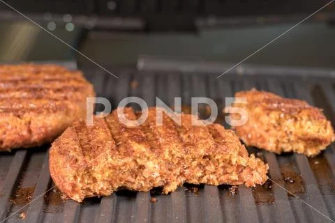 Close up of plant based burger patties on griddle being grilled Stock Photos