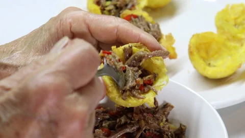 Close-up of plantain baskets being filled with shredded meat Video stock 132454633