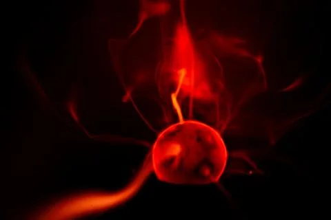 Close-up of a plasma ball globe glowing with red light and energy electrici.. Stock Photos
