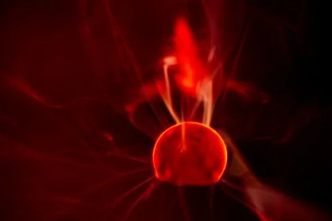 Close-up of a plasma ball globe glowing with red light and energy electrici.. Stock Photos