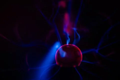 Close-up of a plasma ball globe glowing with red light and energy electrici.. Stock Photos