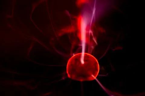 Close-up of a plasma ball globe glowing with red light and energy electrici.. Stock Photos