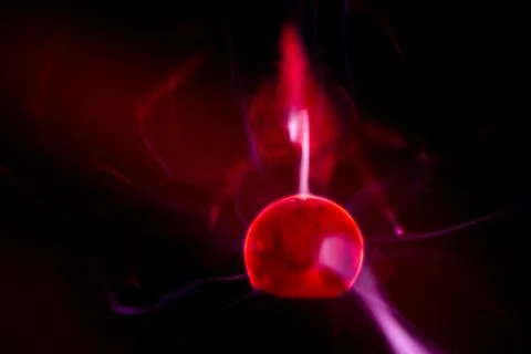 Close-up of a plasma ball globe glowing with red light and energy electrici.. Stock Photos