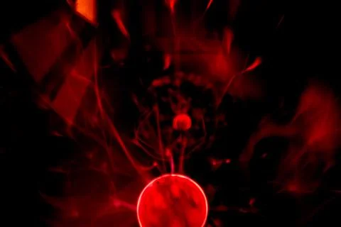 Close-up of a plasma ball globe glowing with red light and energy electrici.. Stock Photos