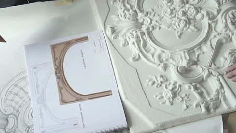 Close up of plaster molding sample being compared with drawn draft Stock Footage 92353852