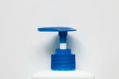 A close-up of a plastic bottle with a pump on a white background. Packaging w Stock Photos