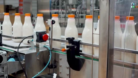 Close-up plastic bottles with milk transported on automated production line. Stock Footage 135787750