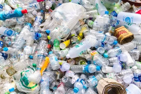 Close up of plastic bottles of various drinks in the park for recycling. Stock Photos