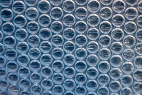 Close-Up Plastic Bubble Wrap Sheet with Soft Blue Lighting Texture Stock Photos