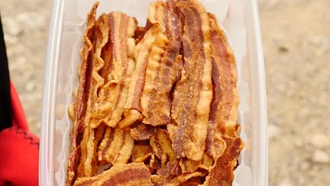Close-up of plastic container of cooked bacon. Video stock 106789254