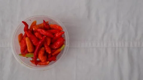 A close-up of a plastic container filled with vibrant red, orange, and gree.. Foto stock