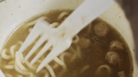 Close up of plastic fork scooping hot instant noodles in broth 스톡 동영상 347238664