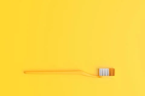 Close-up plastic toothbrush on the yellow background with copy space Stock Illustration