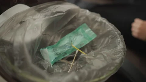 Close up of plastic trash bin filled with green packaged sterile waste and Stock Footage 345072423