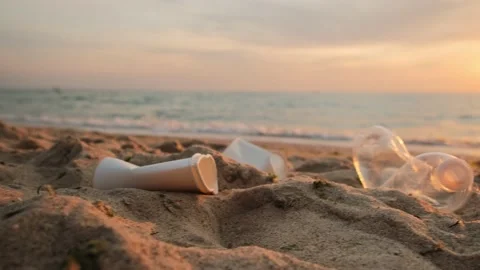 Close-up of plastic trash, garbage on the beach. Empty bottle and paper cups Stock Footage 197540806