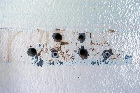 Close up of plastic wall plugs inside drilled holes on dirty concrete wall... Stock Photos