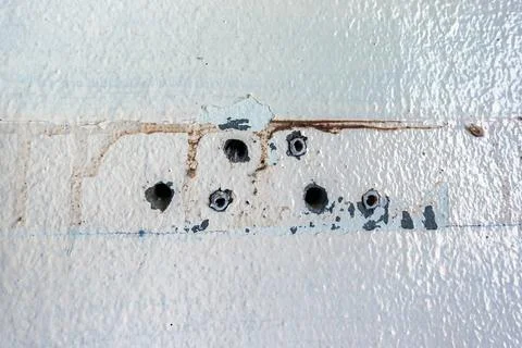 Close up of plastic wall plugs inside drilled holes on dirty concrete wall... Stock Photos