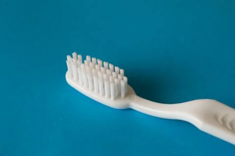 Close up plastic white tooth brush on blue background dental hygiene Stock Photos