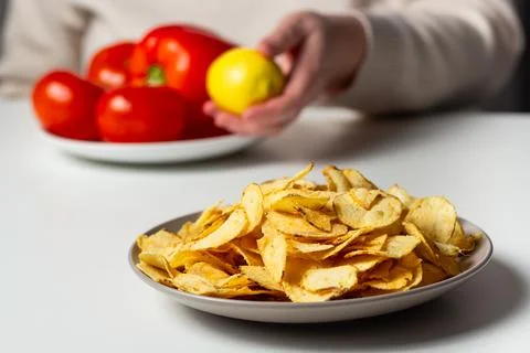 Close up of plate with fried chips. Plate with vegetables in background 스톡 사진