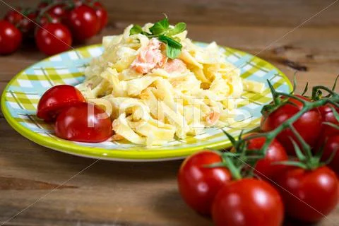 Close-up of plate of pasta and smoked salmon with tomato Stock Photos