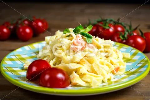 Close-up of plate of pasta and smoked salmon with tomato Stock Photos