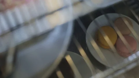 A close-up of a plate with three macaroons behind a shop window Vidéo 114088525