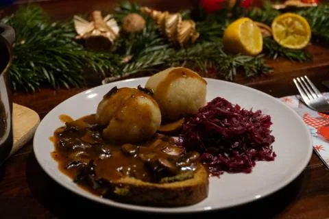 Close up of a plate with two dumplings, red cabbage, a roast and brown sauce  Stock Photos