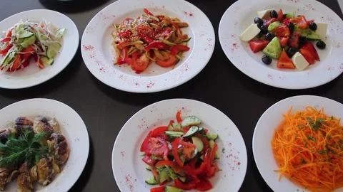 Close-up of a plate with vegetable salads on a black wooden table. Stock Footage 238764957