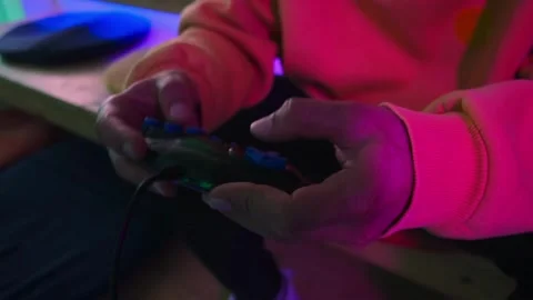 Close-up of players' hands holding a joystick. With a wireless console game 스톡 동영상 334653446