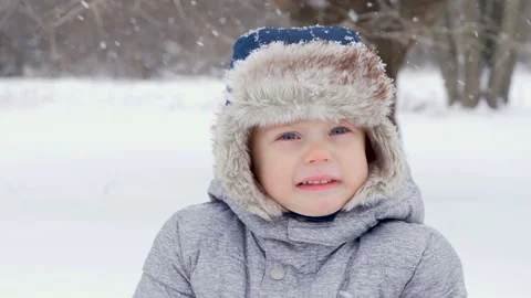 Close-up of playful fun kid little boy face catching snowflakes  his mouth. Cute Видео 101569602