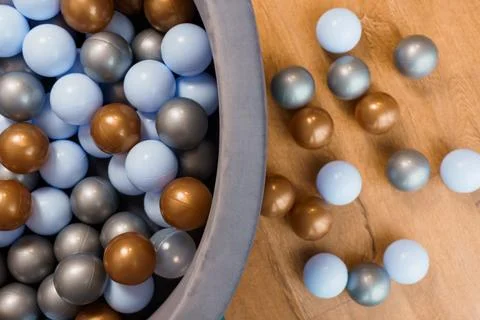 Close-up of Playful Multicolor Plastic Balls in Grey Container on Wooden Su.. Stock Photos