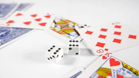 Close up of a playing cards with double six dice thrown onto a white surface Stock Footage 89186955