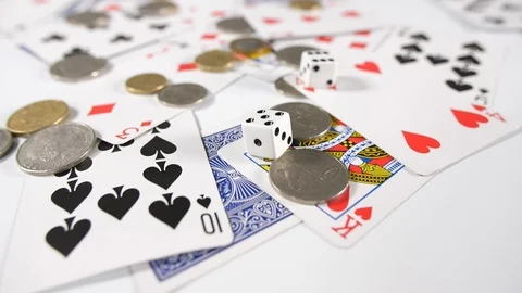 Close up of playing cards with gold and silver coins and two rolling dice throw Stock Footage 89189649