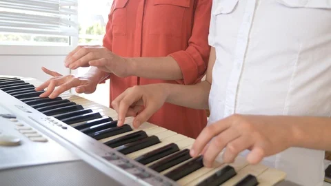 Close-up. playing the piano in four hands. feminine and child's hands play Stock-Footage 90222434
