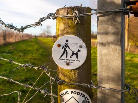 Close up of please keep your dog on a lead circle white and black country wal Stock Photos