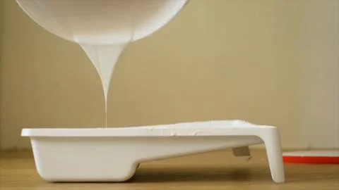 Close-up plot of pouring a viscous light substance from a can. Pouring acrylic Stock Photos