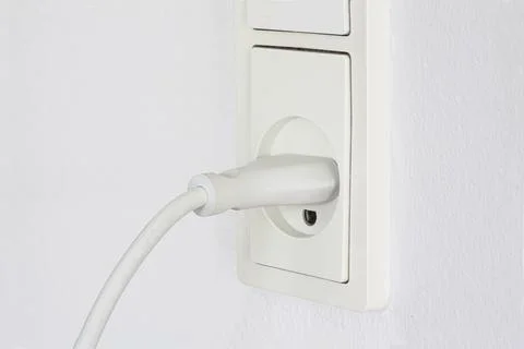 Close up of plug plugged into an electrical outlet Stock Photos