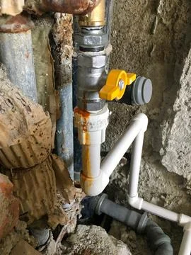 Close Up of Plumbing Setup with Yellow Handled Valve and PVC Pipes Stock Photos