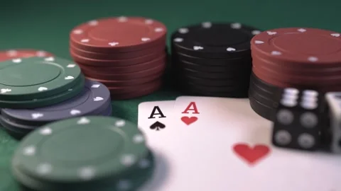 Close up of poker chips and playing cards of two aces on a green table Video stock 281490610