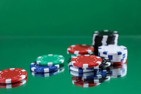 Close up of poker playing chips falling on a green table under the water drop Stock Photos