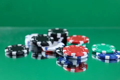 Close up of poker playing chips falling on a green table under the water drop Stock Photos