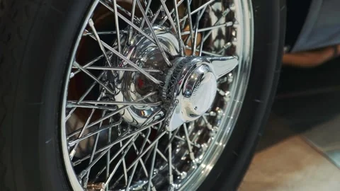 Close-up of polished chrome classic car wheel in indoor showroom Video stock 340880185
