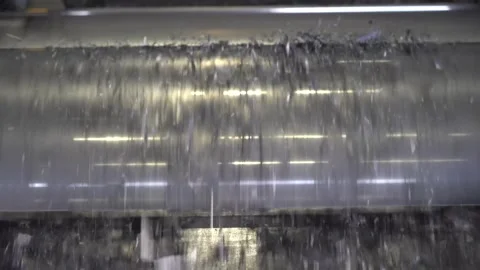 Close up of polished steel conveyor rollers with fine graphite flakes falling 動画素材 347123890