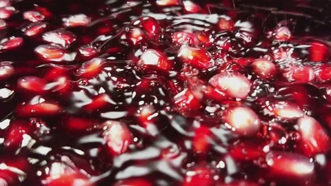 Close-up of pomegranate grains falling down into the red juice in slow motion Stock Footage 148422669