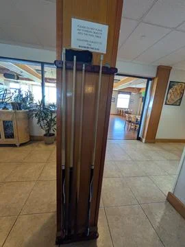 Close-up of a pool cue rack and warning sign Stock Photos